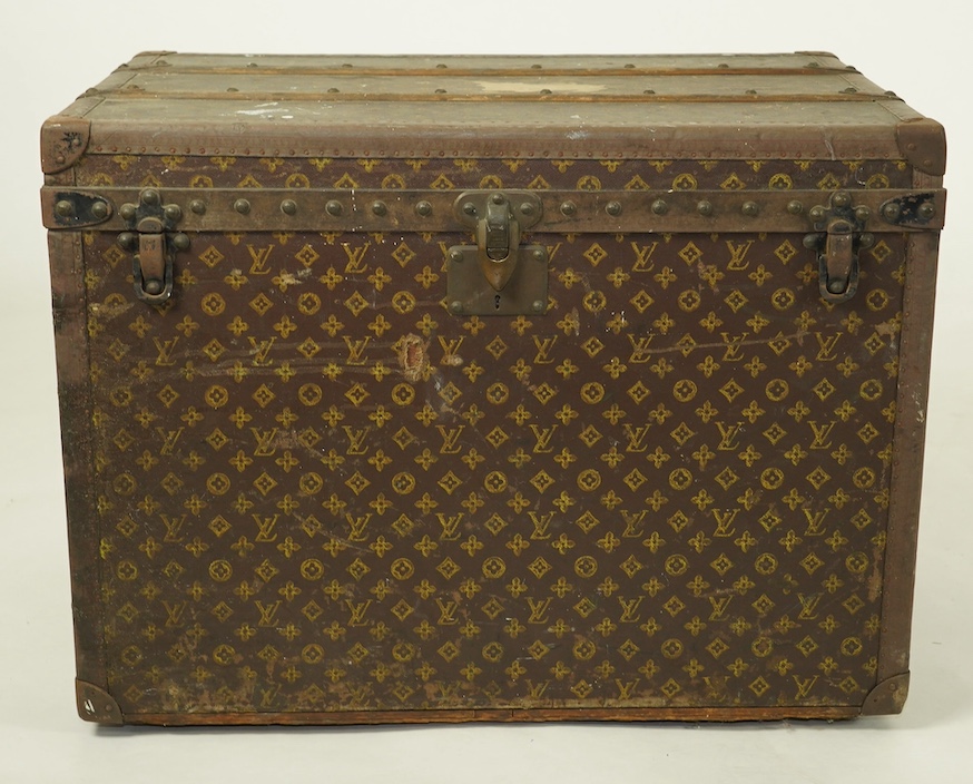 A vintage Louis Vuitton trunk, with black painted iron banding, wooden slats and canvas LV fabric, label for Paris, New Bond Street, Nice and Lille, numbered 776719, the interior with original tray, 76cm wide, 49cm deep,